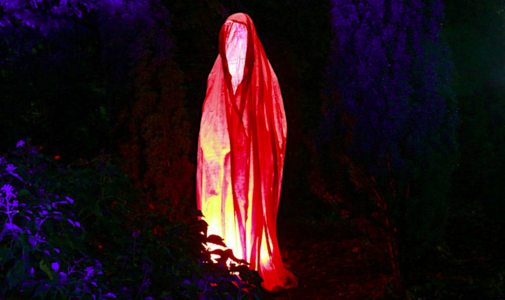 A sinister red spectre haunts a woodland at night. It appears as a hooded robe, empty(?), yet radiating evil. Original image by Humpelfinkel.